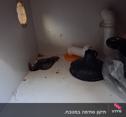 כלים וחלקי אינסטלציה בארון מתחת לכיור